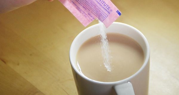 Süßstoff rieselt in Kaffeetasse