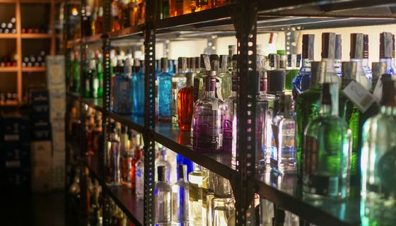 Regal mit vielen bunten Alkohol-Flaschen.