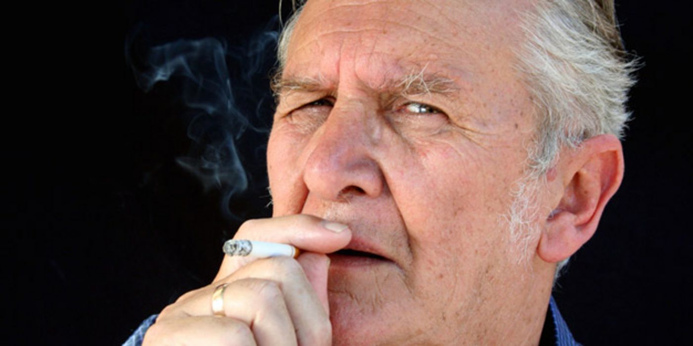 Ein älterer Mann, der eine Zigarette raucht.