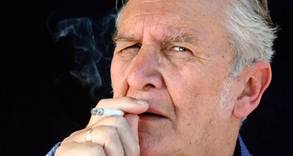 Ein älterer Mann, der eine Zigarette raucht.