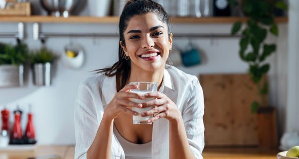 Junge Frau trinkt ein Glas Milch.