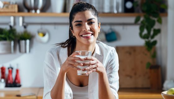 Junge Frau trinkt ein Glas Milch.