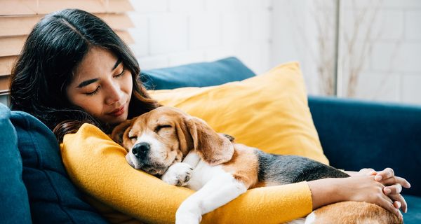 Frau, kuschelt mit Hund.