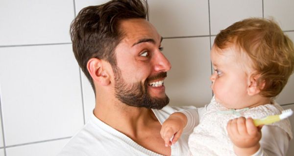 Vater mit Baby beim Zähneputzen