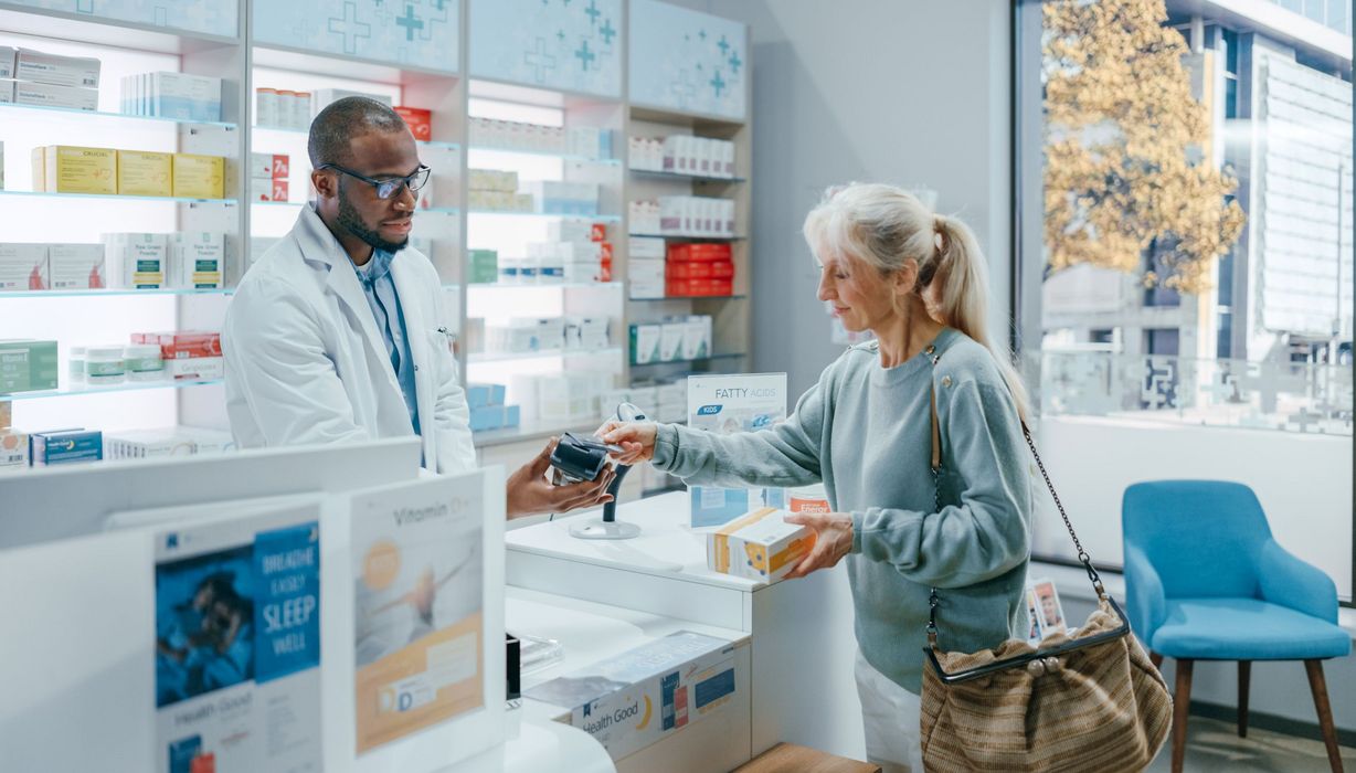 Frau, besorgt sich ein Medikament in der Apotheke.