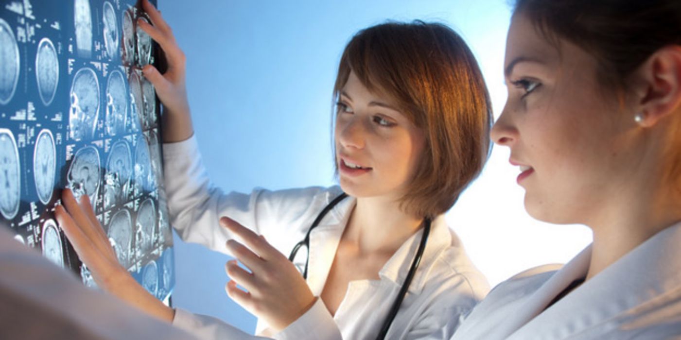 Zwei junge Ärztinnen betrachten MRT-Aufnahmen.
