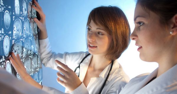 Zwei junge Ärztinnen betrachten MRT-Aufnahmen.