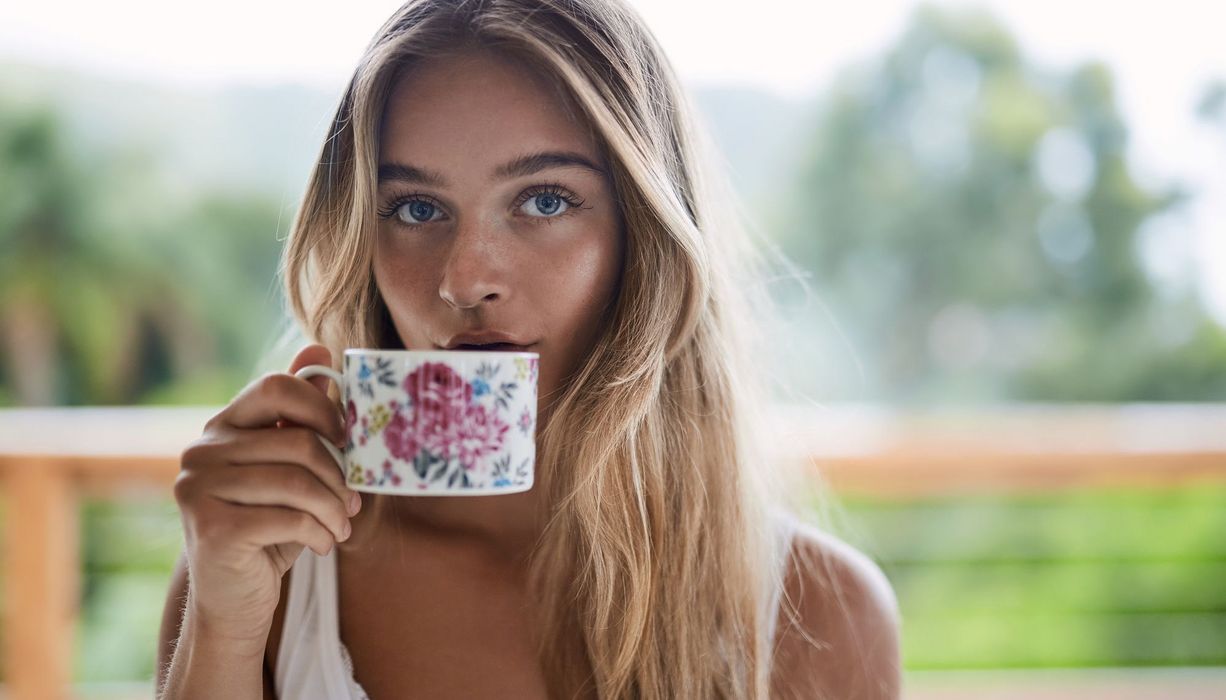 Junge blonde Frau mit einer Tasse Tee.