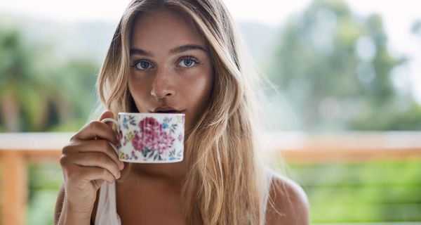 Junge blonde Frau mit einer Tasse Tee.