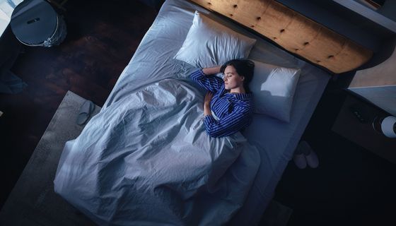 Frau, liegt im Bett und schläft.