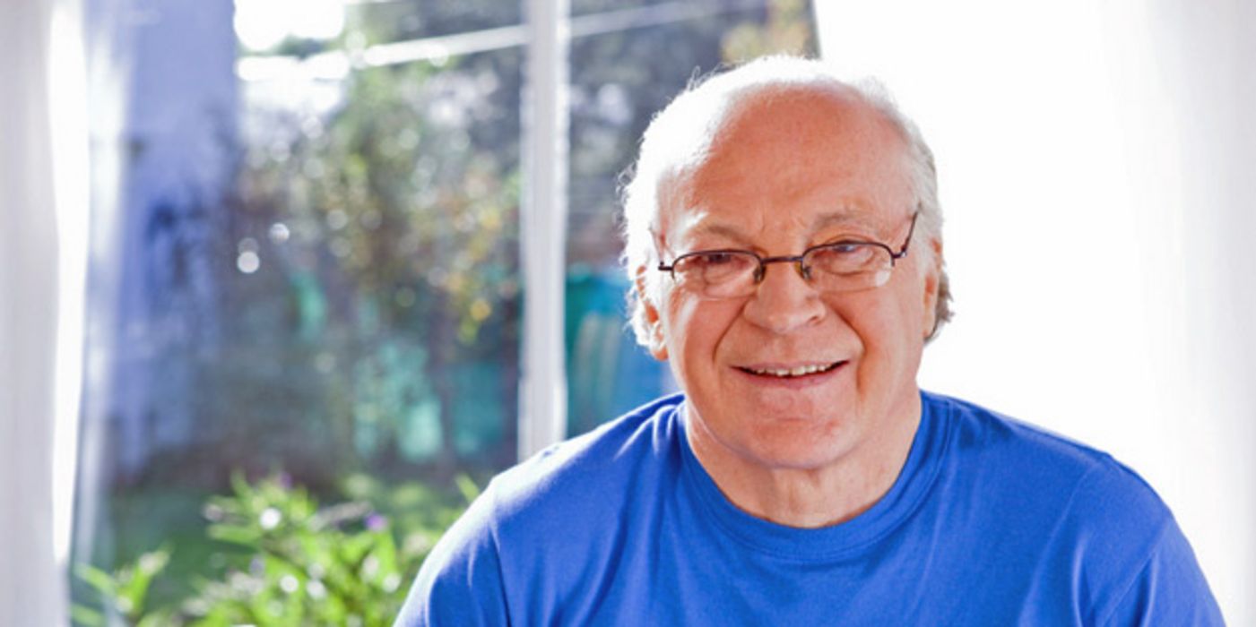 Älterer Mann mit blauem T-Shirt und Brille