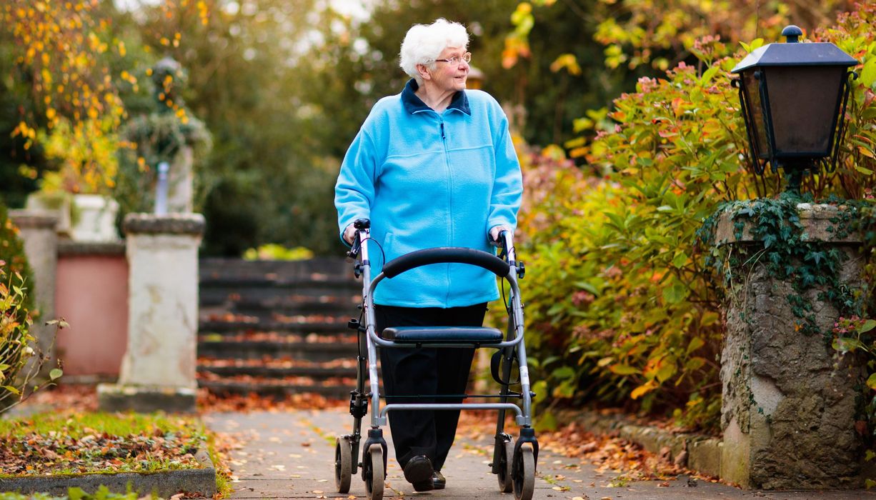 Ältere Frau mit Rollator.