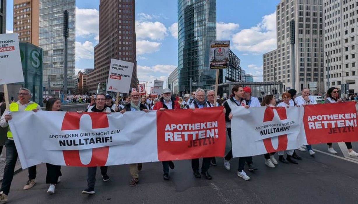Demonstrationszug in Berlin: Sie tragen ein breites Banner mit der Aufschrift "Apotheken gibt's nicht zum Nulltarif!" und "Apotheken retten jetzt!"