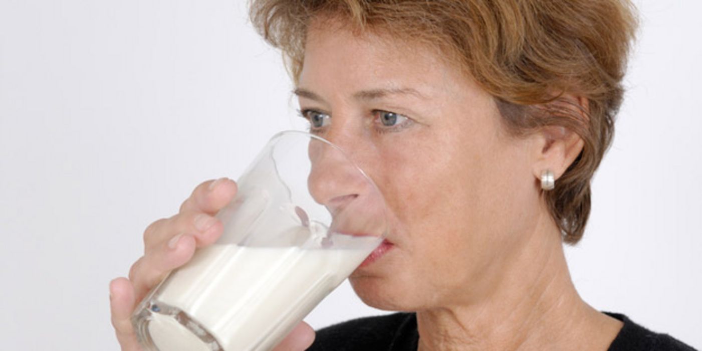 Ältere Frau trinkt Milch.