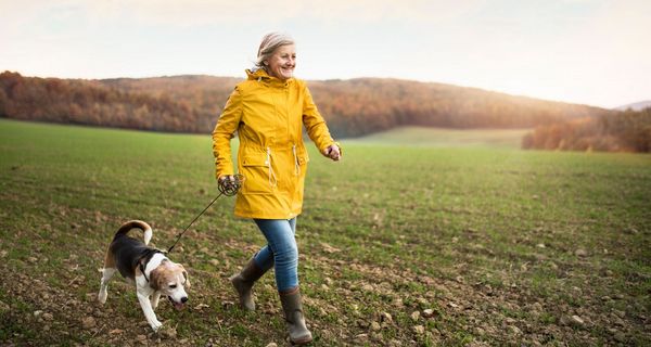 Ältere Frau, geht mit ihrem Hund spazieren.