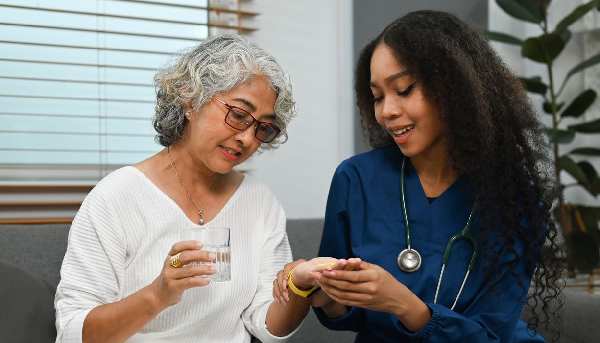 Eine Medizinerin gibt einer Patientin Medikamente sowie Erklärungen dazu. 