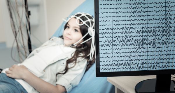 Ein Kind liegt angeschlossen an ein EEG auf einer liege im Krankenhaus.