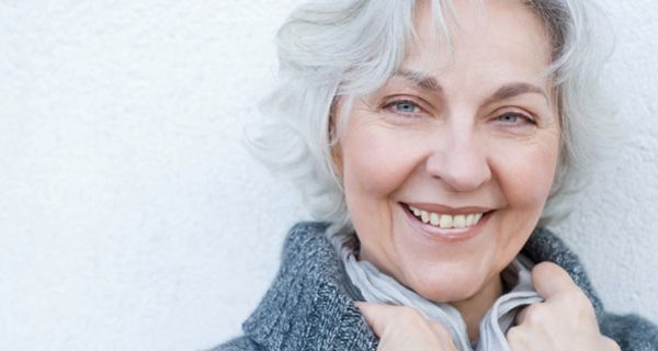 Lächelnde Frau mit grauen Haaren.