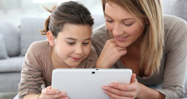 Mädchen und junge Mutter schauen sich auf einem Tablet-PC ein Video an