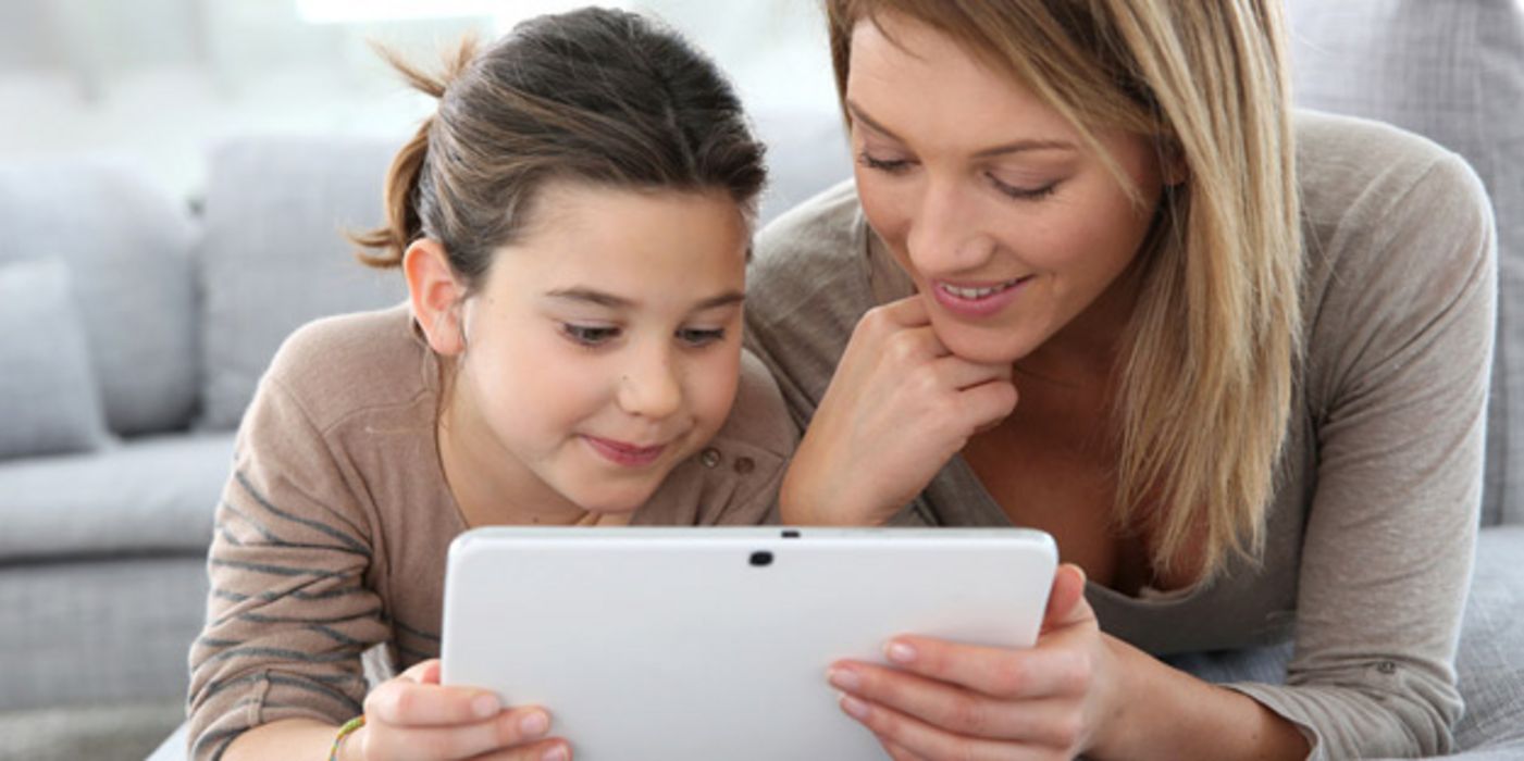 Mädchen und junge Mutter schauen sich auf einem Tablet-PC ein Video an