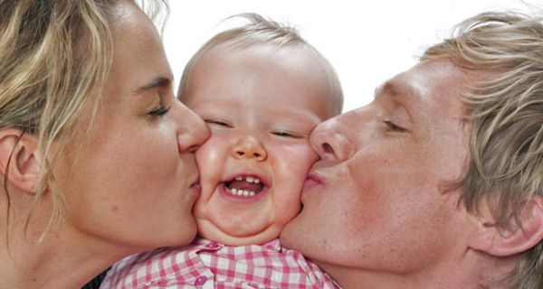 Mutter und Vater küssen ihr Baby.