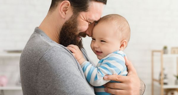 Vater, hält sein Baby auf dem Arm.