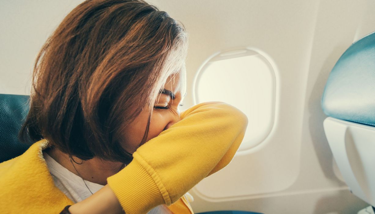 Frau, hat Schnupfen im Flugzeug.
