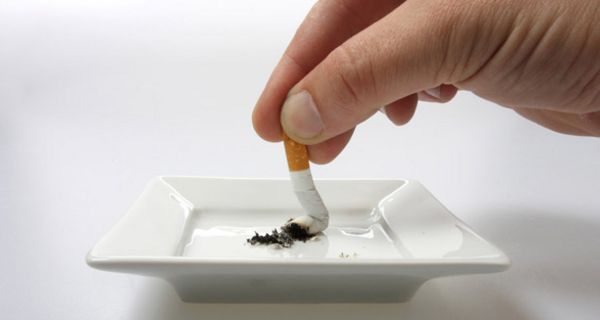Zigarette wird in Aschenbecher zerdrückt.