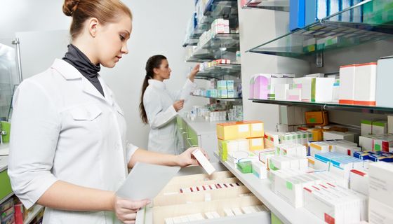 Zwei Apothekerinnen, sortieren Medikamente in einem Lager.
