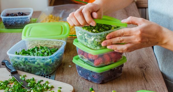 Frau packt Lebensmittel in Tupperware.