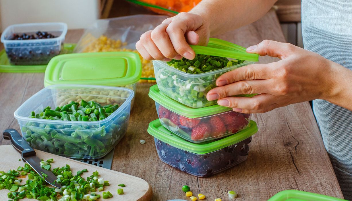 Frau packt Lebensmittel in Tupperware.