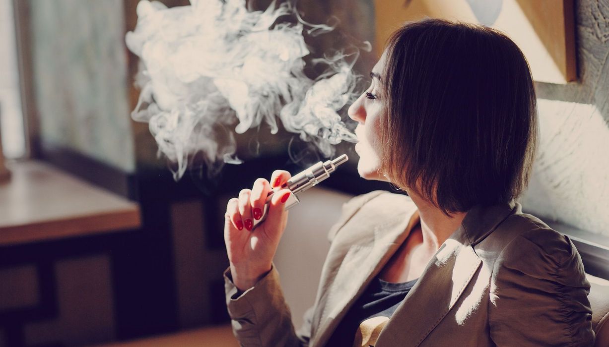 Junge Frau, nutzt eine E-Zigarette.