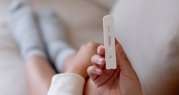 Frau, hält einen negativen Schnelltest in der Hand.