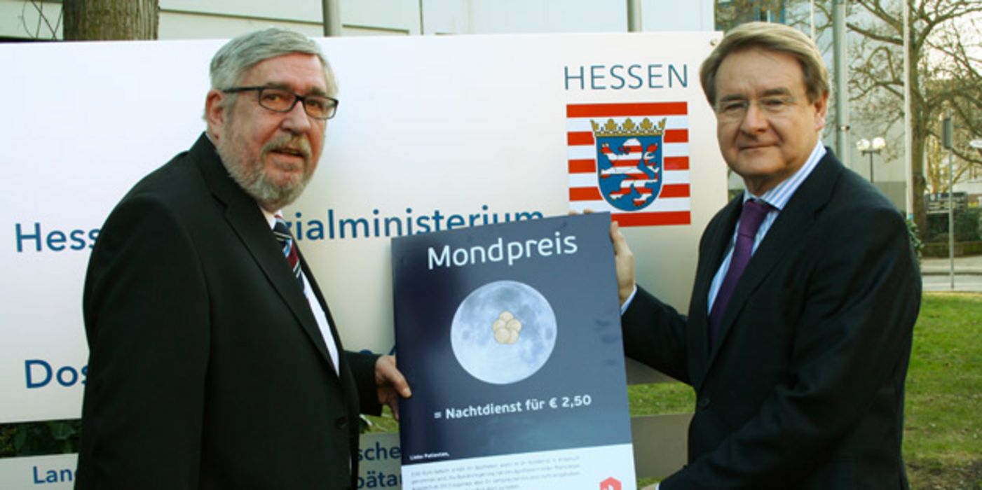 Peter Homann und Jürgen Schneider mit Notdienst-Kampagnen-Plakat vor dem Ministerium.