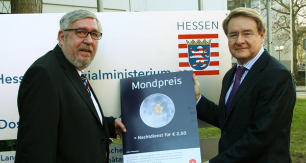 Peter Homann und Jürgen Schneider mit Notdienst-Kampagnen-Plakat vor dem Ministerium.