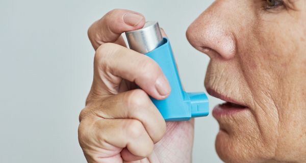 Ältere Frau, nutzt Asthmaspray.