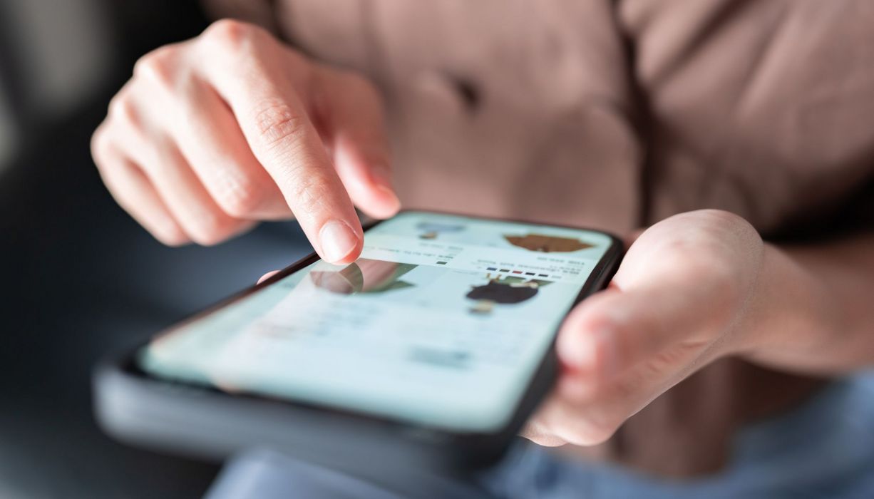 Frau, tippt auf dem Screen ihres Smartphones.