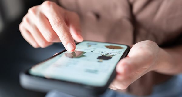 Frau, tippt auf dem Screen ihres Smartphones.