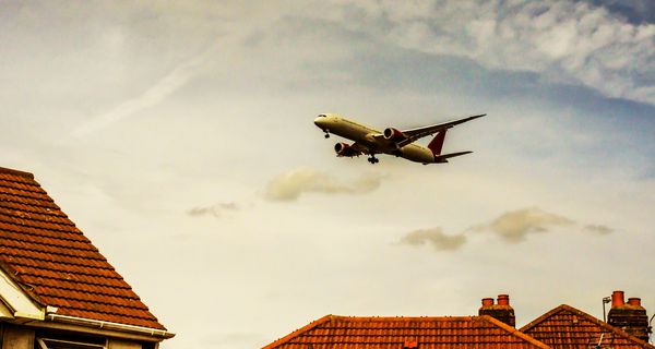 Flugzeug über Häuserdächern.