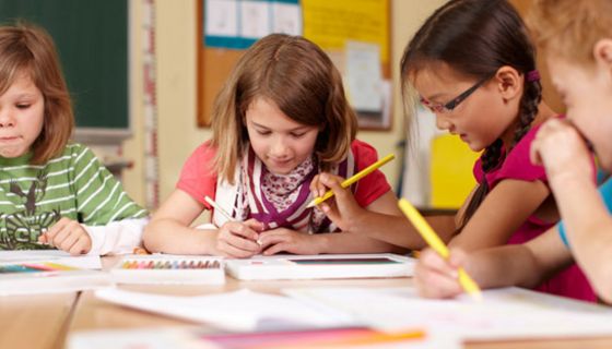Vier Grundschüler arbeiten konzentriert an einem Tisch