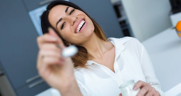 Frau mit Joghurt auf einem Löffel