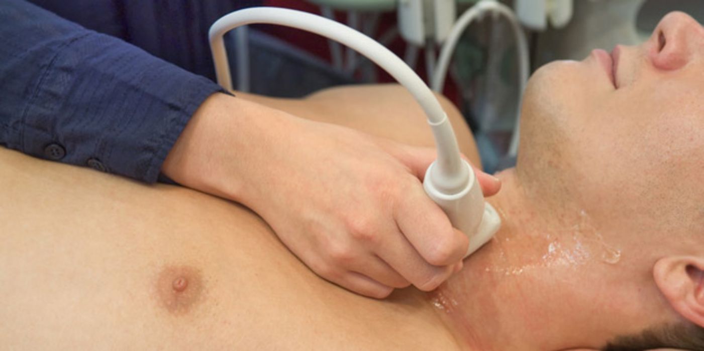 Mann bei einer Ultraschalluntersuchung seiner Schilddrüse