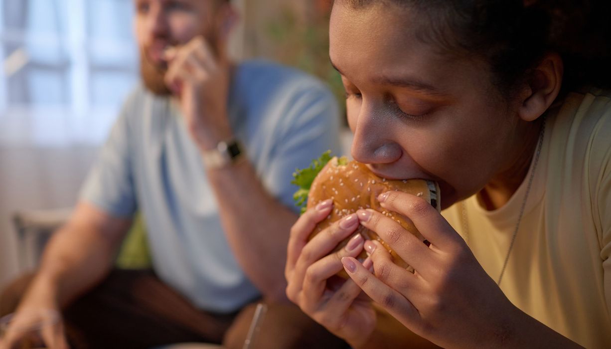 Frau, beißt in einen Burger.