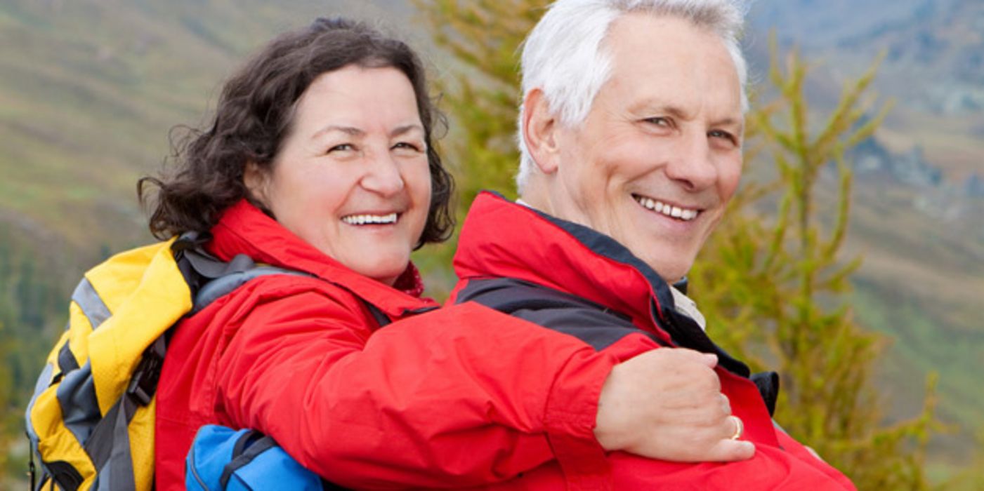 Älteres Paar in roten Jacken beim Wandern