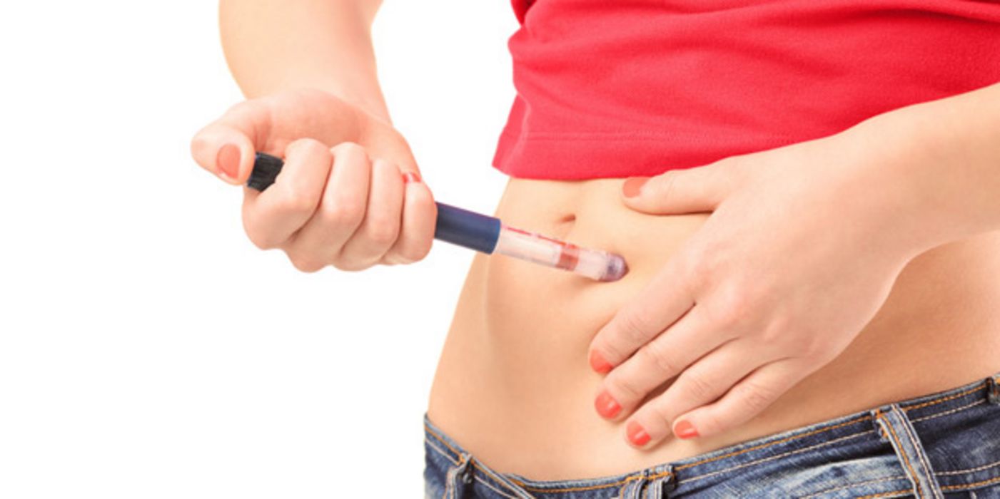 Bauchbild Jeansansatz, rotes Shirt, freier Bauch: Junge Frau spritzt sich Insulin