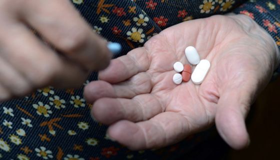 Seniorin hält mehrere Tabletten in der offenen Hand