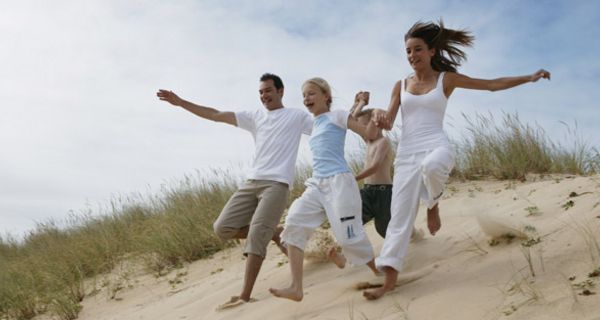 Familie läuft eine Düne hinunter.