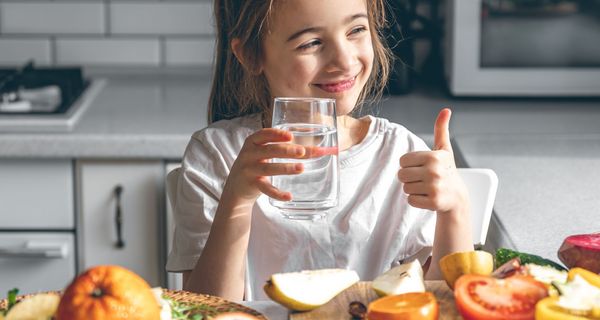 Junges Mädchen, vor Obst und Gemüse.