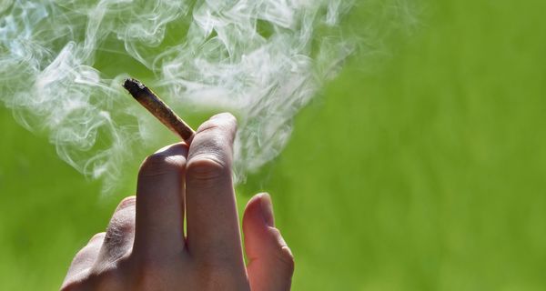 Frau, hält einen Joint in der Hand.