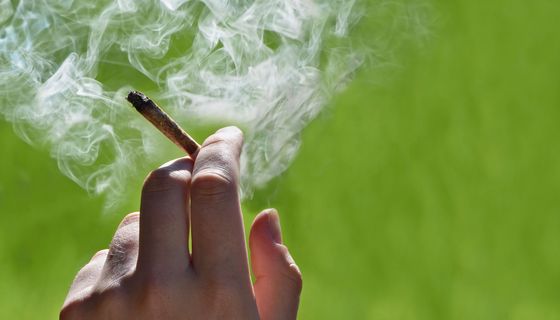 Frau, hält einen Joint in der Hand.